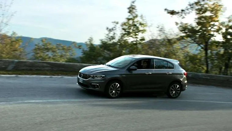 Pilkas automobilis važiuoja kalnų keliu